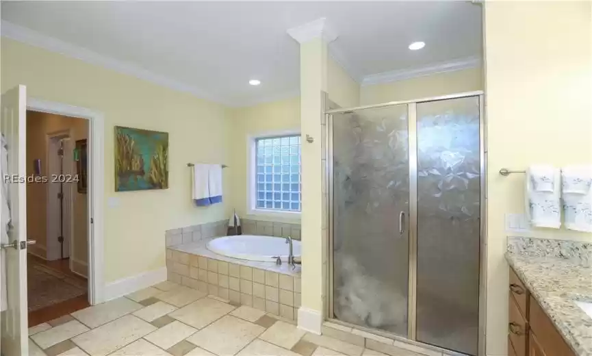 Bathroom with jetted tub, ornamental molding, comfort-height granite counter vanities, and walk-in shower