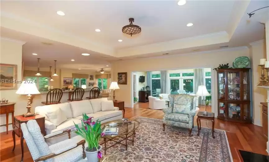 Living room with plenty of natural light, a raised ceiling, ornamental molding, and 5
