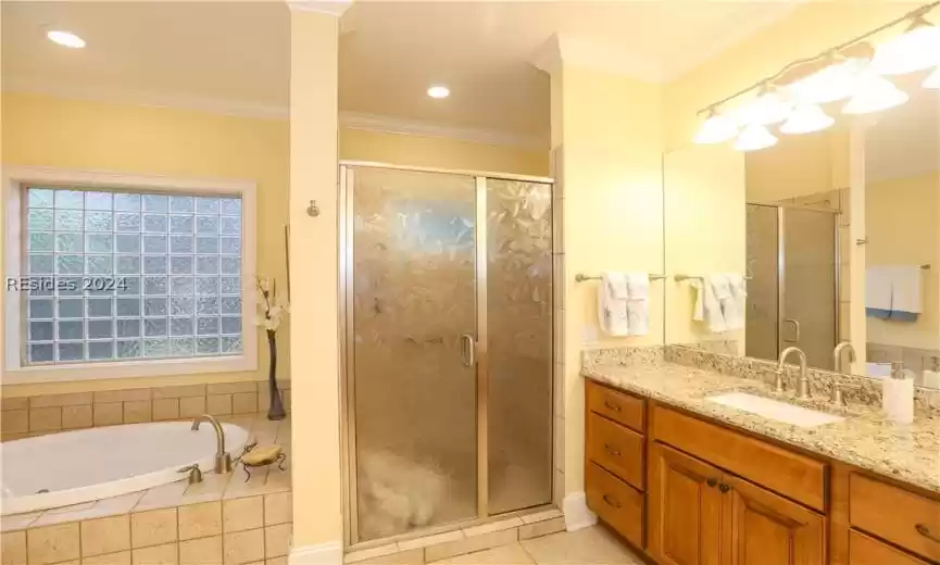Bathroom featuring vanity, tile floors, independent shower and bath, and crown molding