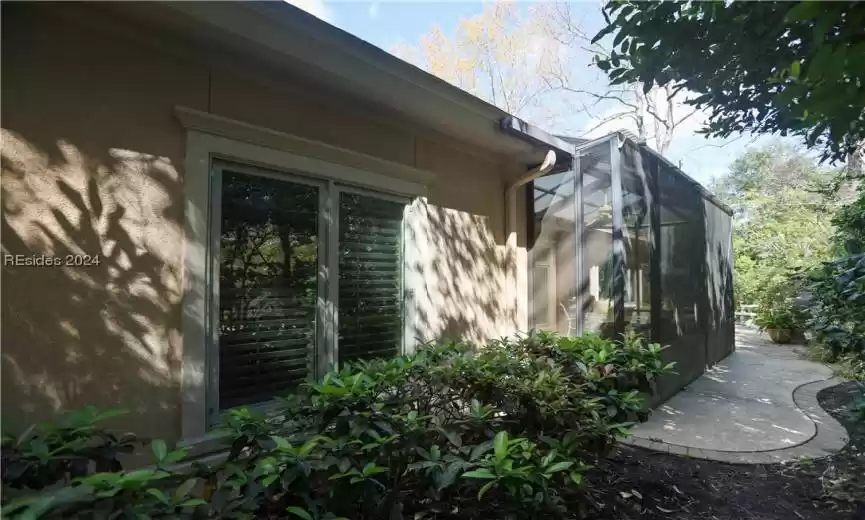 View of property exterior and rear paver patio behind the birdcage lanai.