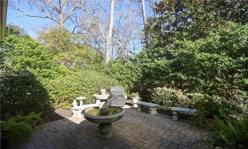 View of paver patio, fountain, natural gas connected Weber grill and concrete benches which convey.  Statue & bird bath may not convey.