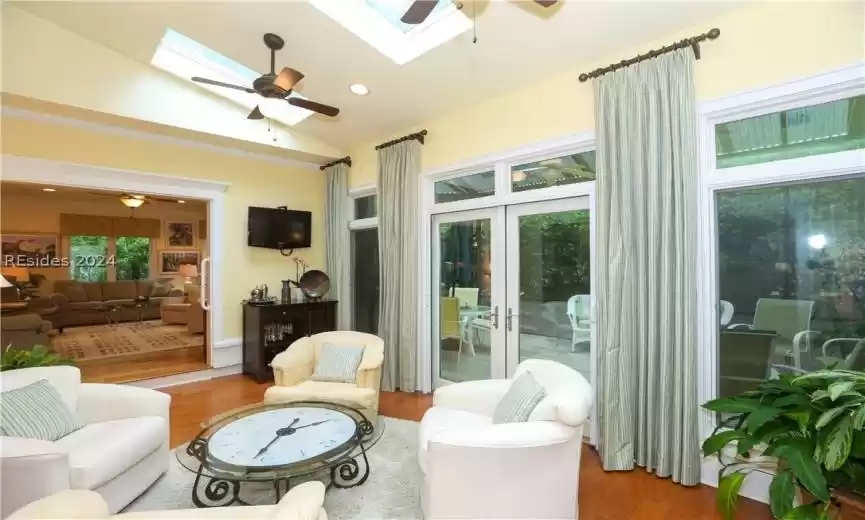 Living room with ceiling fan, a skylight, and 5