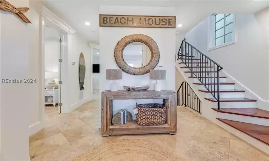 Welcoming entrance/ foyer with wrought iron stairway up to living areas on the 3rd floor.  Hallway on left to 2 other bedrooms.