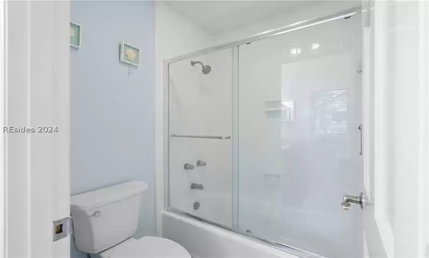 Primary Bathroom showing separate area with toilet and glass shower/tub enclosure.