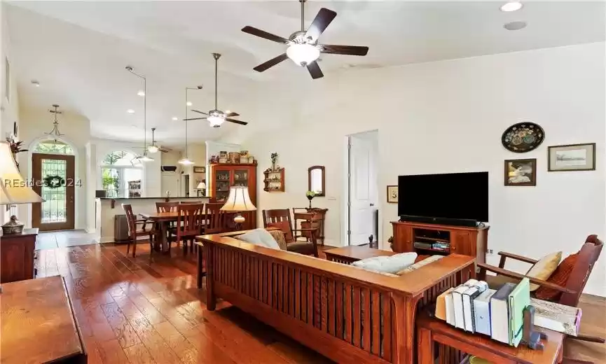 Living room featuring high vaulted ceiling, dark hardwood / wood-style flooring, and ceiling fan