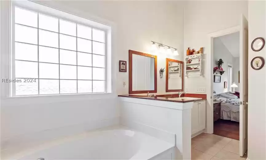 Bathroom with plenty of natural light, walk in Shower, soaking tub, and tile floors