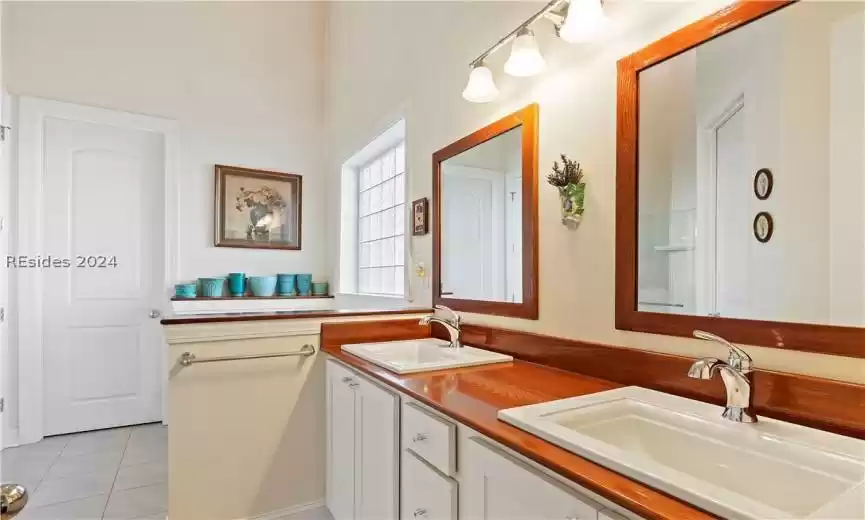 Bathroom with dual vanity and tile flooring