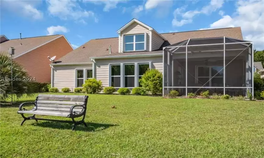 Rear view of house featuring a yard and a lanai