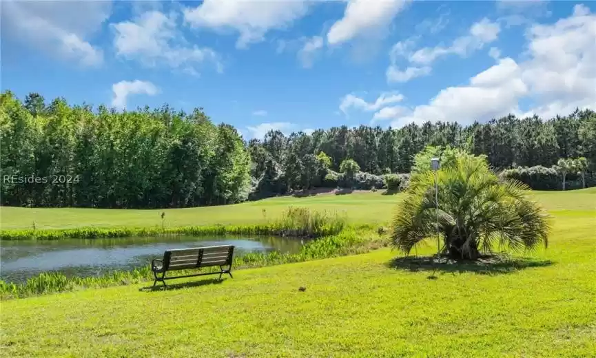 Surrounding community featuring a water view and a lawn