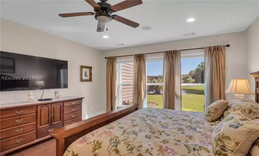 Bedroom with access to outside, ceiling fan, and hardwood / wood-style floors