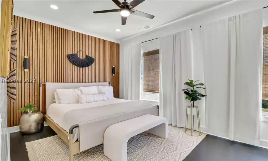 Primary Bedroom with dark hardwood / wood-style flooring, multiple windows, and ceiling fan