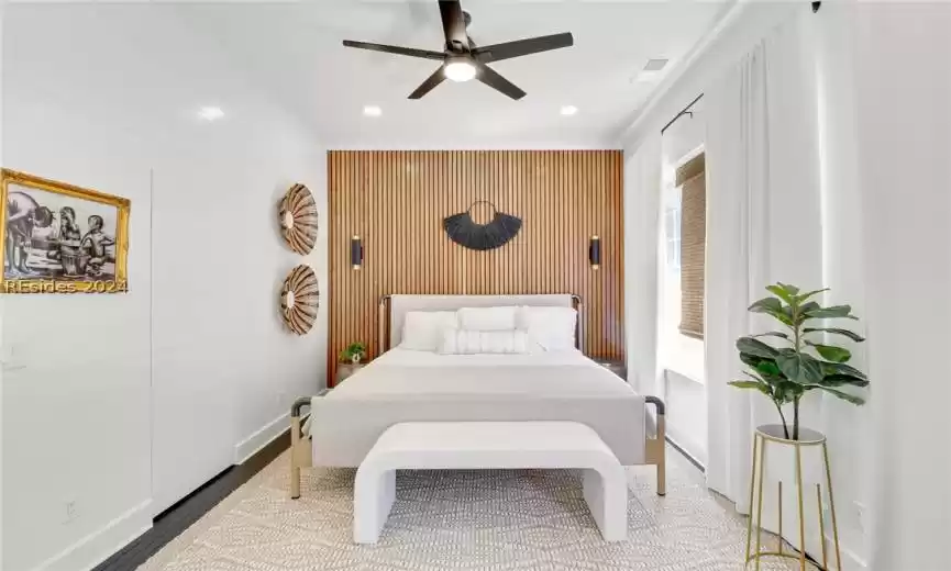 Primary Bedroom with ceiling fan, dark wood-type flooring, and hidden door