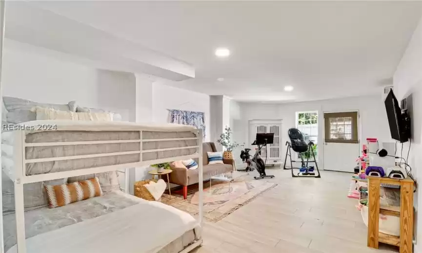 Exercise room / Guest Bedroom 3 with ornate columns and light wood-type flooring