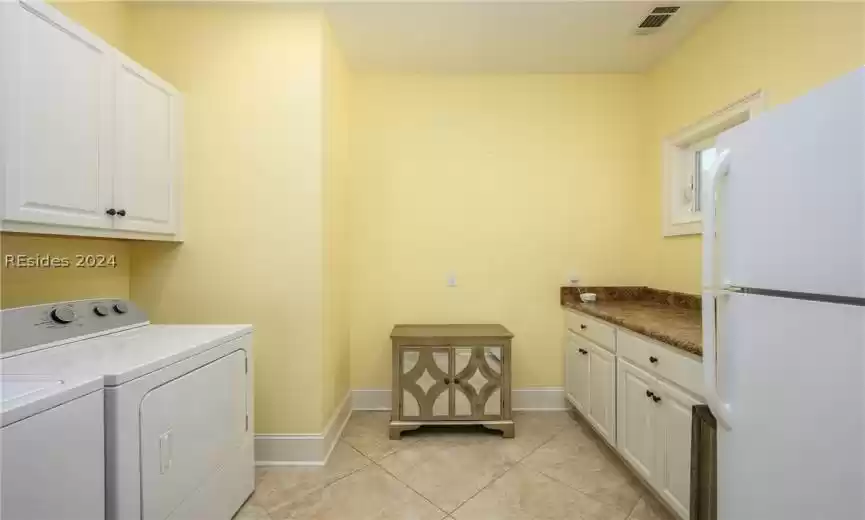 Everyone wants a big and private laundry room and this offers just that! Cabinets over washer and dryer, lower cabinets with countertops, transom window for natural light and space for a fridge or freezer, too. (This refrigerator does not stay.)