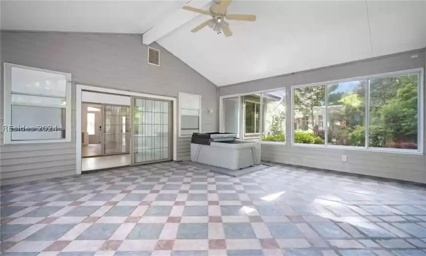 Sunroom with ceiling fan and vaulted ceiling