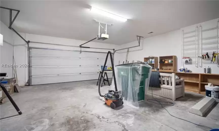 Garage with a garage door opener and a workshop area