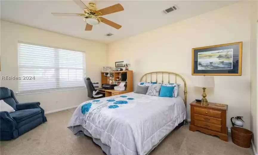 Carpeted bedroom featuring ceiling fan