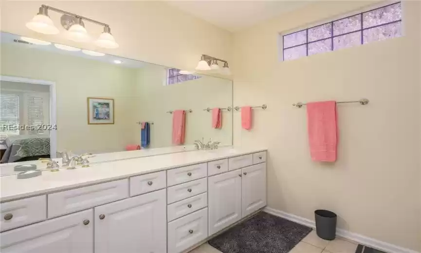 Bathroom with tile flooring and dual bowl vanity