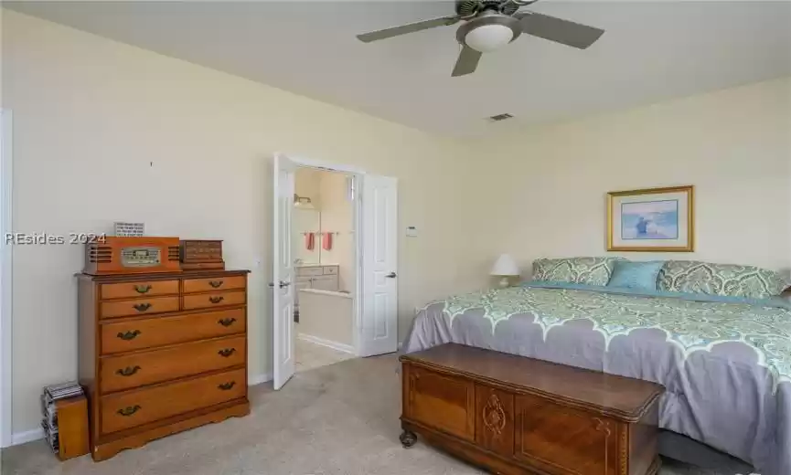 Tiled bedroom with ensuite bath and ceiling fan
