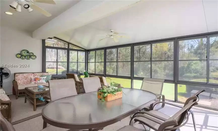Sunroom featuring a wealth of natural light, lofted ceiling with beams, and ceiling fan