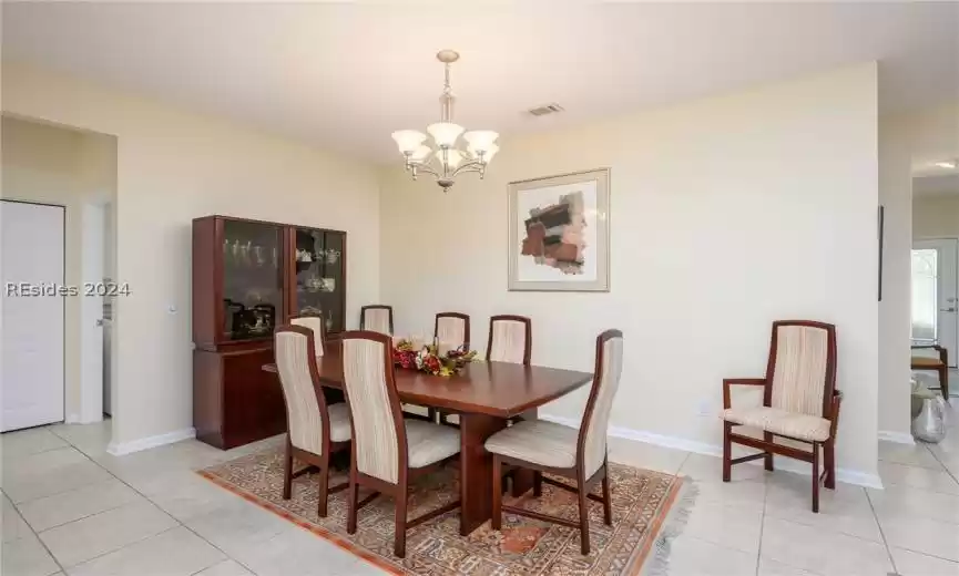 Dining area featuring a notable chandelier and light tile floors