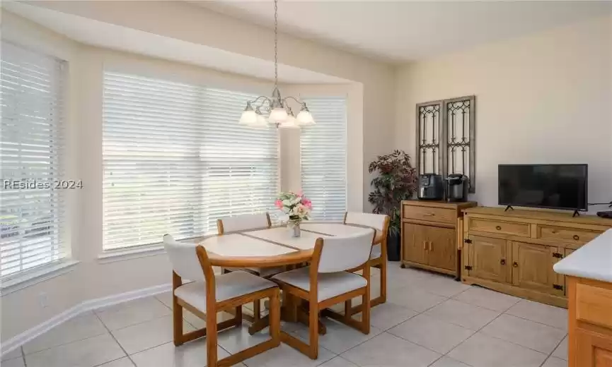 Dining space featuring light tile flooring and an inviting chandelier