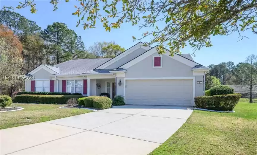 Ranch-style home with a garage and a front lawn