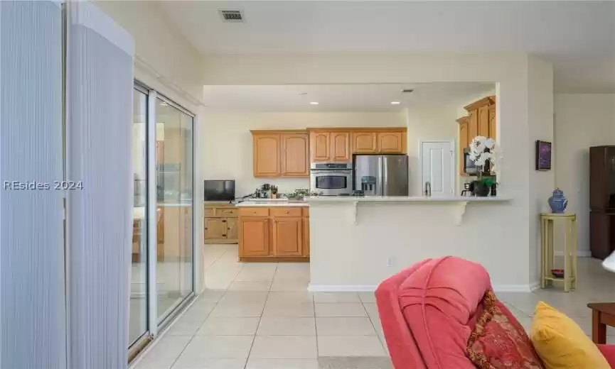 Kitchen featuring sink, a breakfast bar area, light tile floors, kitchen peninsula, and stainless steel appliances