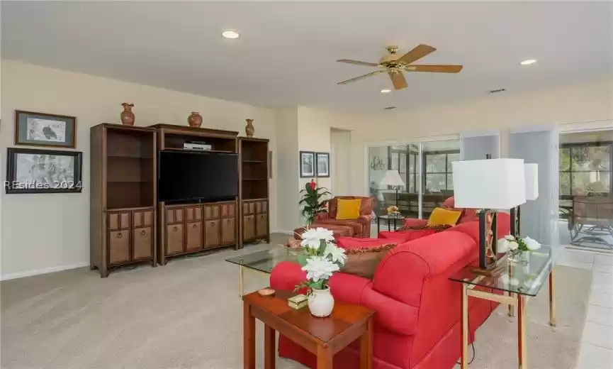 Carpeted living room with ceiling fan