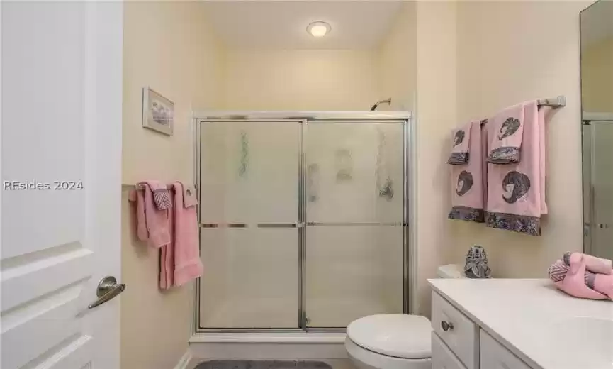 Bathroom featuring walk in shower, vanity, and toilet