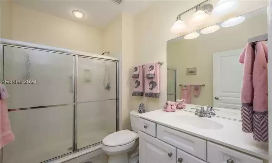 Bathroom featuring vanity, toilet, tile flooring, and an enclosed shower