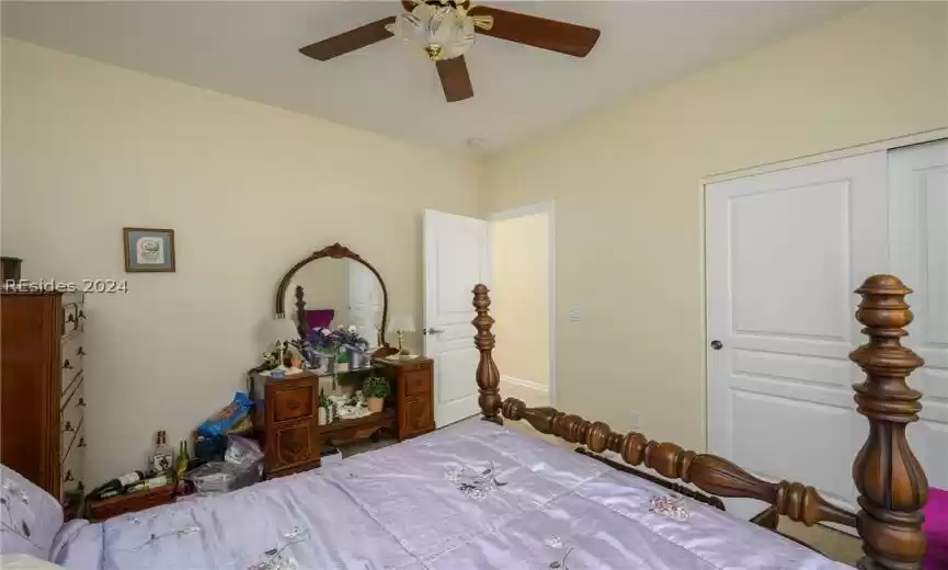 Bedroom featuring a closet, light colored carpet, and ceiling fan