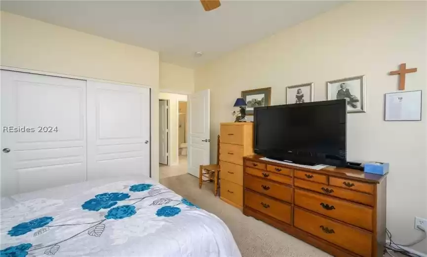 Bedroom featuring light carpet, a closet, and ceiling fan