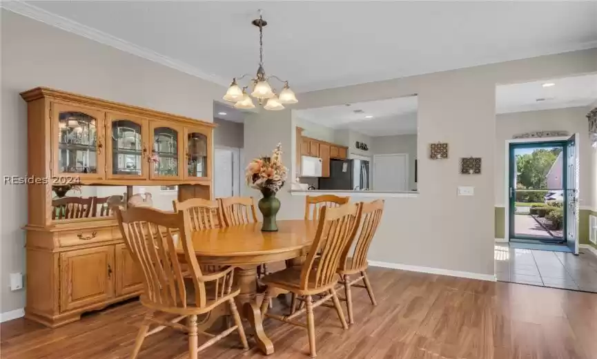 Dining area featuring a chandelier, crown molding, and light wood-type flooring