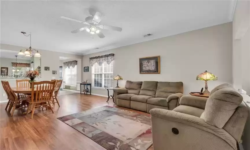 Living room with crown molding, hardwood / wood-style flooring.