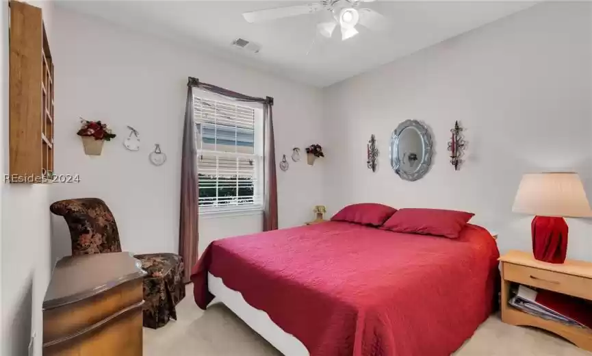 Carpeted bedroom featuring ceiling fan