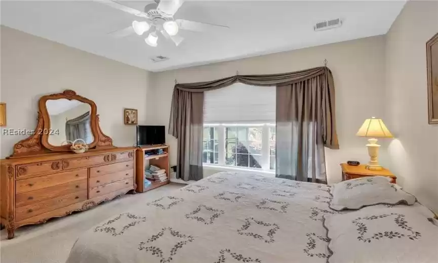 Bedroom with light colored carpet and ceiling fan