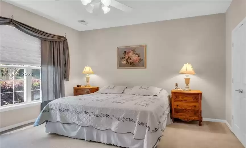 Carpeted bedroom with ceiling fan