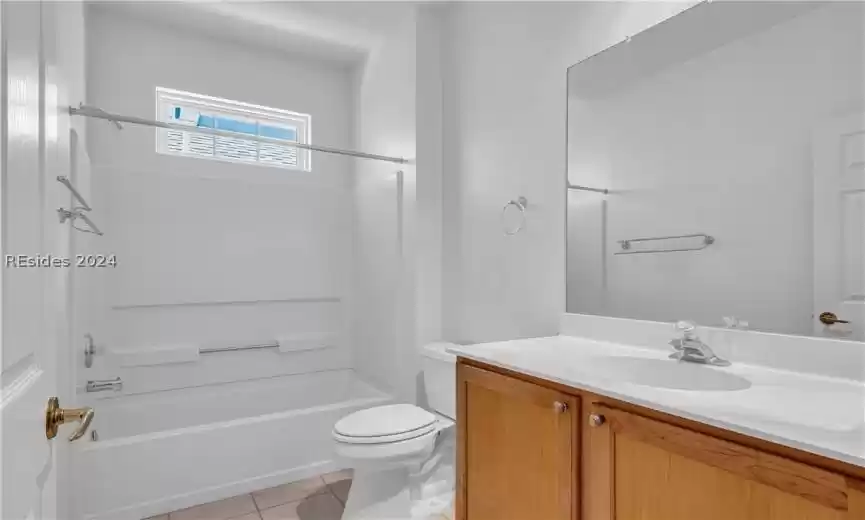 Full bathroom with bathtub / shower combination, large vanity, tile floors, and toilet