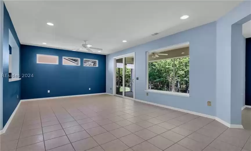 Unfurnished room with ceiling fan and light tile floors