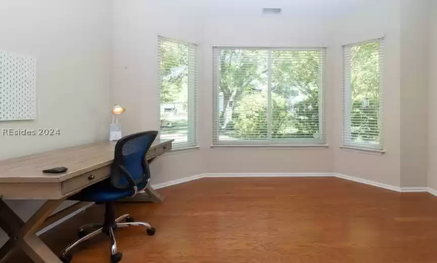 Office/study with bay window and hardwood floors.