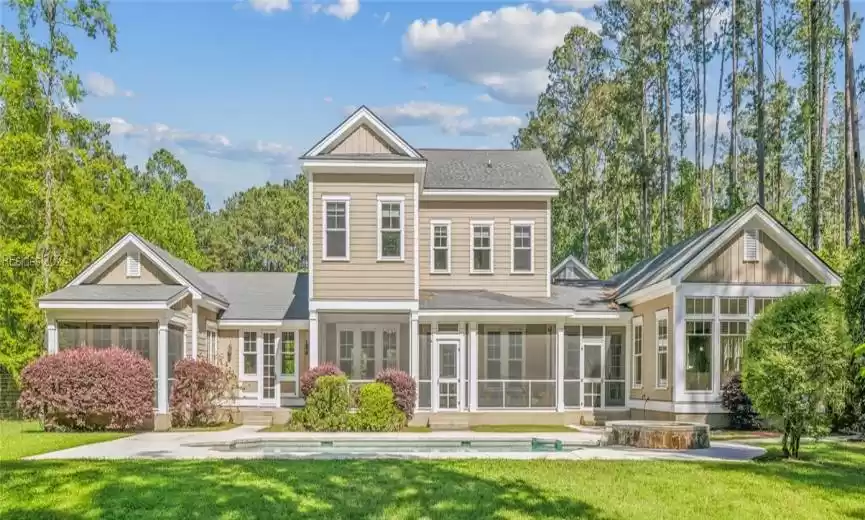 Rear view of property featuring a sunroom and pool