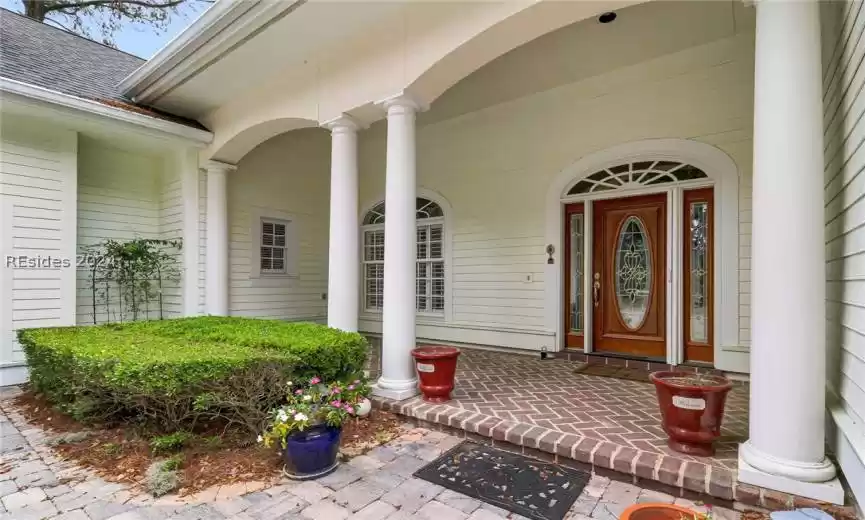 Brick front porch with leaded glass wood door and sidelights