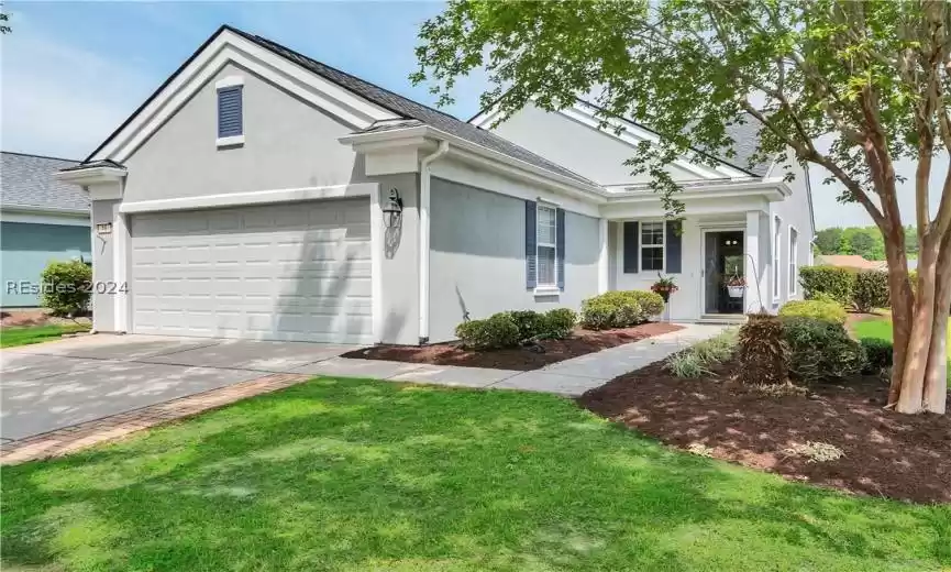 Single story home featuring a garage and a front lawn