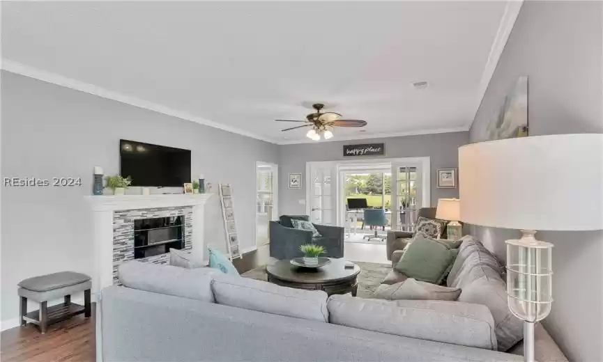 Living room with ceiling fan, crown molding, and dark hardwood / wood-style floors