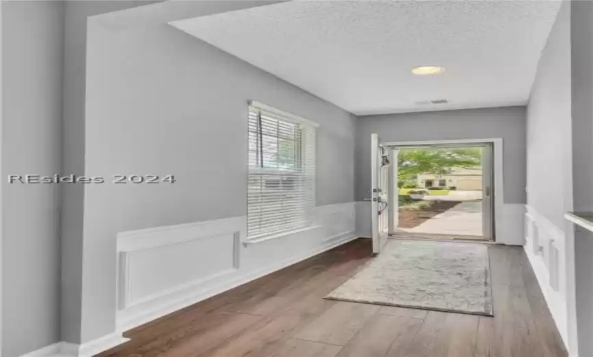 Doorway featuring a wealth of natural light, dark hardwood / wood-style floors, and a textured ceiling