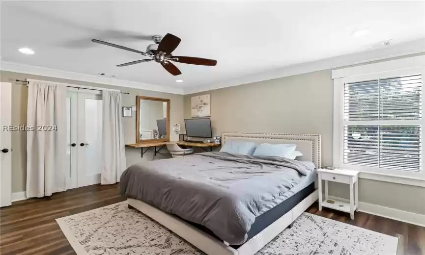 Primary Bedroom featuring dark hardwood / wood-style floors, ceiling fan, and ornamental molding