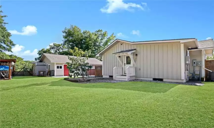 Rear view of house with a yard and a storage shed