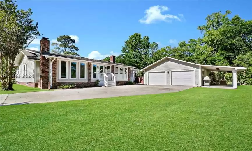 Ranch-style house with a front yard and a carport / 2 car garage