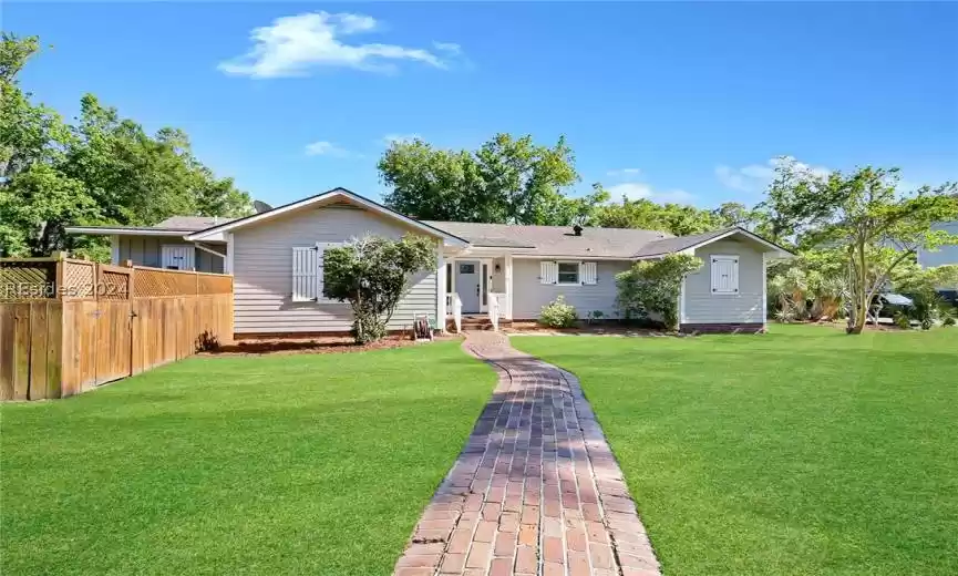 Ranch-style home featuring a front lawn